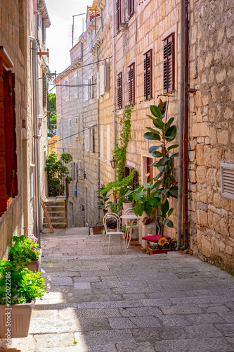 Narrow stone street with stone houses and facades and flowers in historic fortified Korcula town  Korcula Island  Dalmatia  Croatia