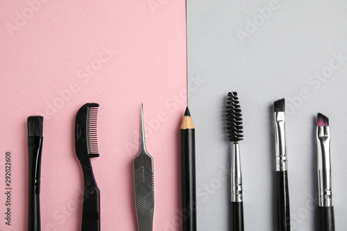 Set of professional eyebrow tools on color background, flat lay