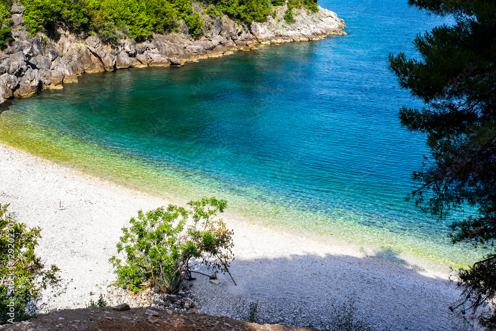 Blue lagoon, clear blue sea water, stone beach, sunny day, very popular touristic destination, village Racisce, island Korcula, Damatia, Croatia Blue lagoon, clear blue sea water, stone beach, sunny day, very popular touristic destination, village Racisce, island Korcula, Damatia, Croatia