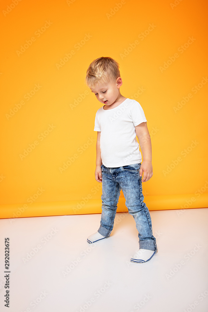 Fashionable little boy posing in jeans.