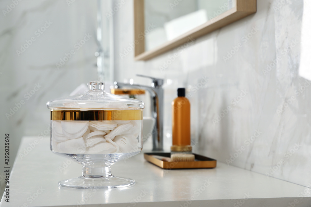 Jar with cotton pads on bathroom countertop Jar with cotton pads on bathroom countertop