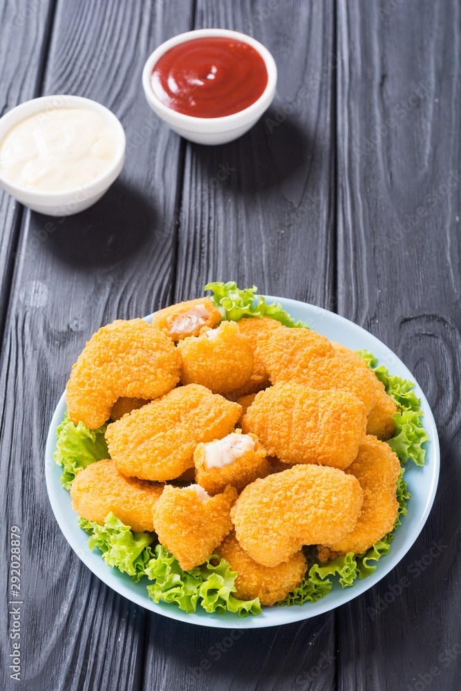 Chicken nuggets in plate on rustic background Chicken nuggets in plate on rustic background