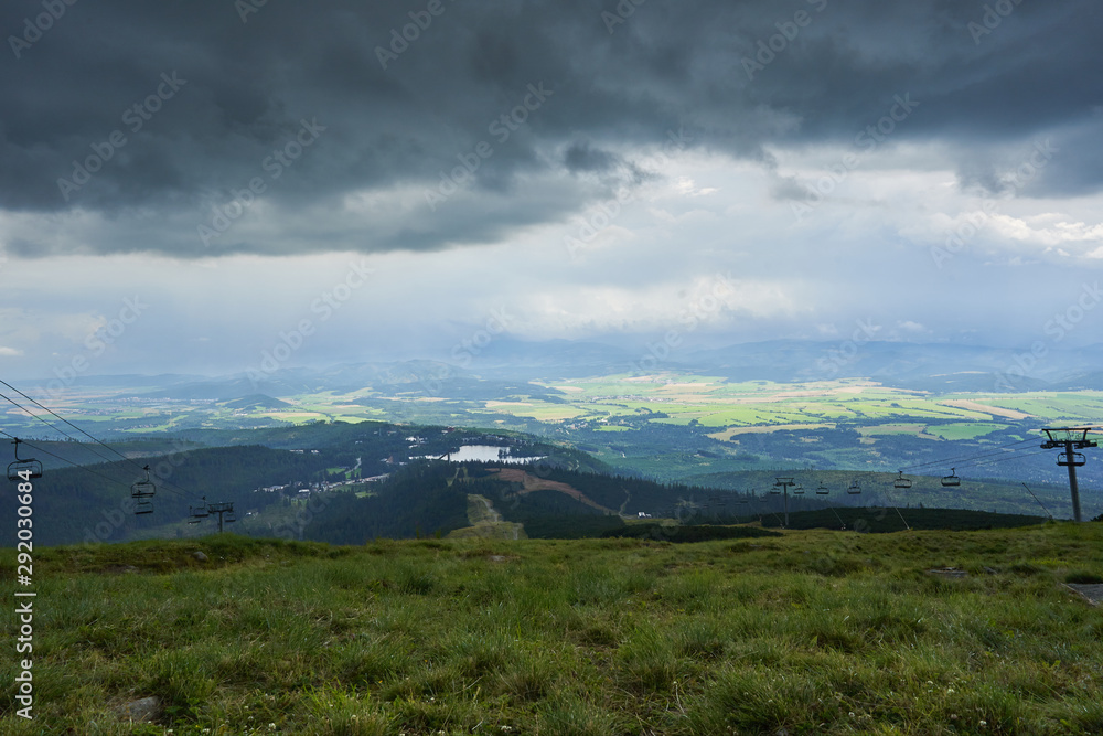 Summer landscape Picture from top station of cableway of ski slope Solisko with view of mountain lake or tran in Strbske Pleso in High Tatras mountains in Slovakia. Picture taken in stormy weather.