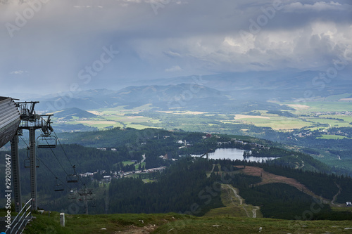 Summer landscape Picture from top station of cableway of ski slope Solisko with view of mountain lake or tran in Strbske Pleso in High Tatras mountains in Slovakia. Picture taken in stormy weather.