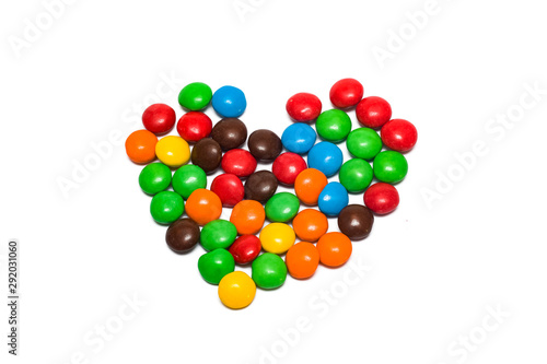 Small multicolored jelly beans as heart isolated on white background photo