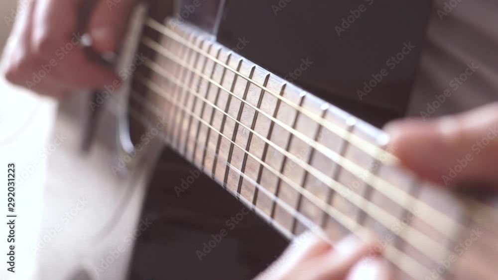 Acoustic guitar strings vibrate while playing. Guitar fretboard and male hand. Acoustic guitar strings vibrate while playing. Guitar fretboard and male hand.