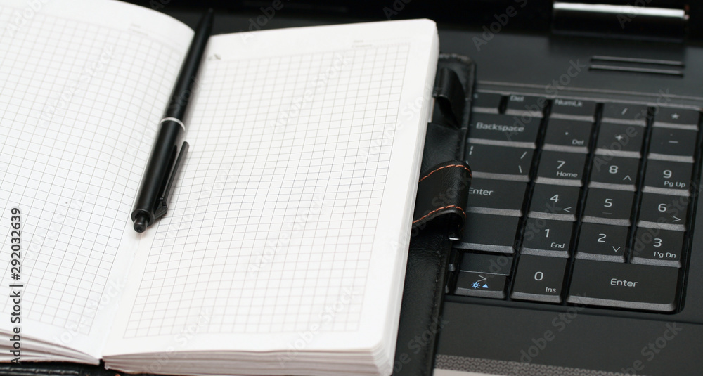 note book lies on the black keyboard note book lies on the black keyboard