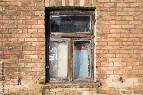 old broken closed window on the brick wall
