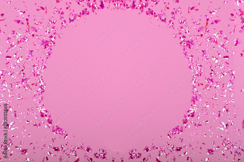Obraz premium Pink confetti glitter sequins on pink background, top view