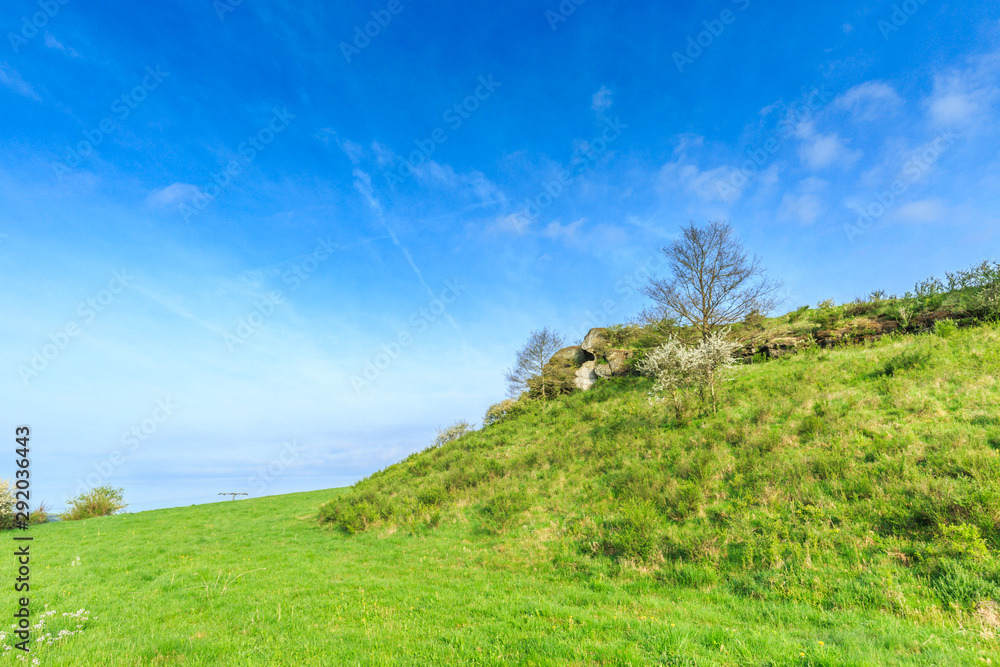 Close up of dolomite rock formation in Vulkaneifel against blue sky with clouds veil