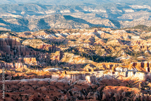 High angle aerial view from overlook of orange hoodoos rock formations in Bryce Canyon National Park at sunset with sunlight