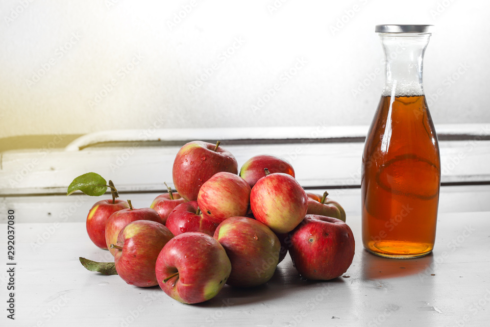 apple juice in glass bottle and apples on Woden Provence table apple juice in glass bottle and apples on Woden Provence table