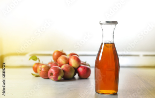 apple juice in glass bottle  and apples on Woden Provence table
