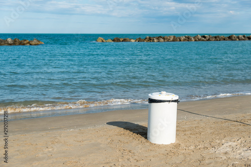 isolated white garbage bin on the beach