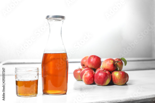 apple juice in glass and bottle and apples on Woden Provence table