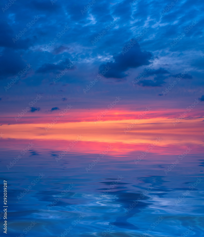 Sunset in the form of three colors of the sky: orange, purple, magenta over the sea.