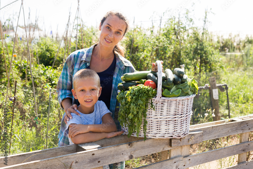 Obraz premium Woman and boy with gathered vegetables