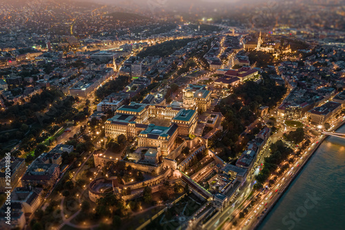 Budapest, Hungary - Aerial drone view of the illuminated Buda Castle Royal Palace at blue hour with Matthias Church at background, using a blurry tilt-shift effect