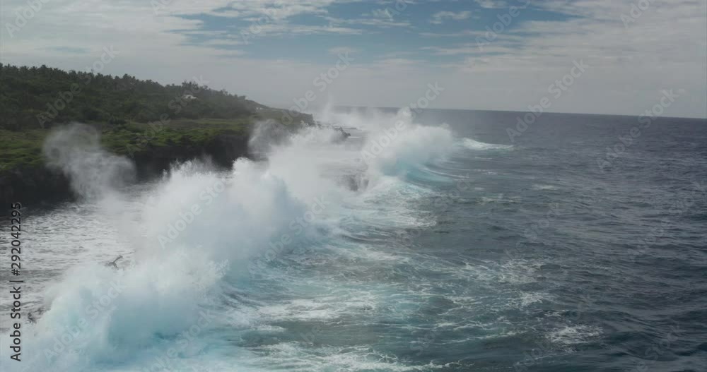 Aerial shot of sea waves are crashing into the rocky cliffs of a desert island before the storm. Aerial shot of sea waves are crashing into the rocky cliffs of a desert island before the storm.