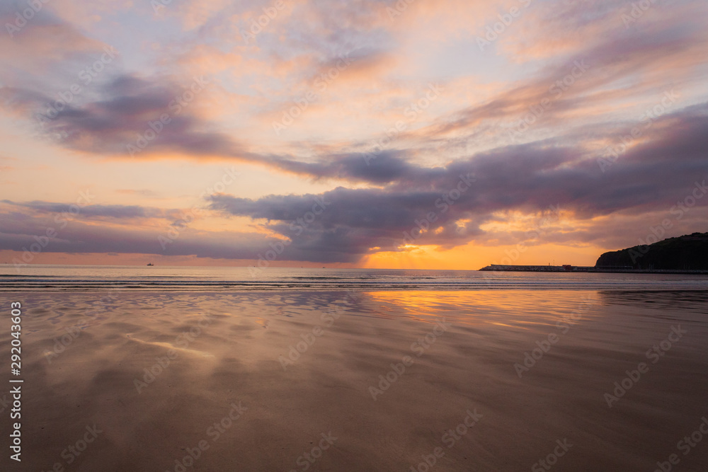Obraz premium a beautiful sunrise on the beach of La Salve, in Laredo, cantabria
