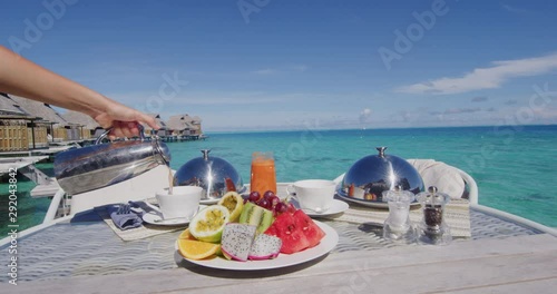 Vacation breakfast table at luxury restaurant or hotel room by the water in the tropics. Romantic honeymoon travel holiday.