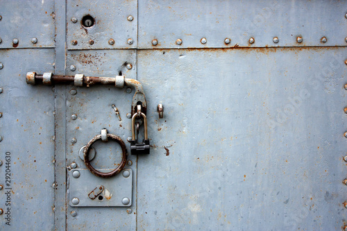 Obraz na plátně View of a closed iron door with rivets, bolts and a lock