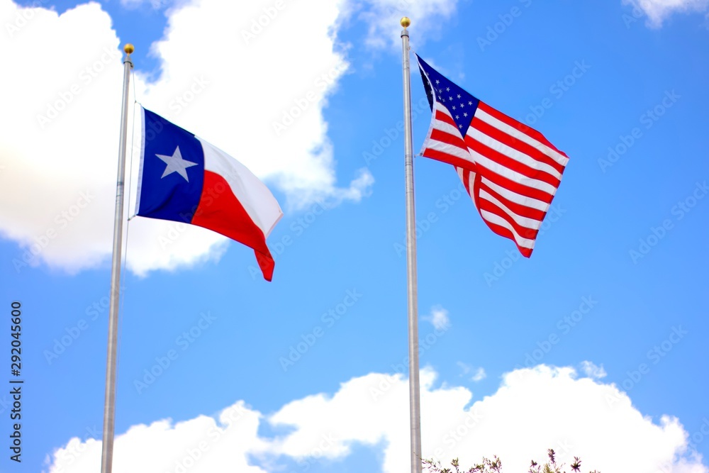 american flag and texas flag at full staff