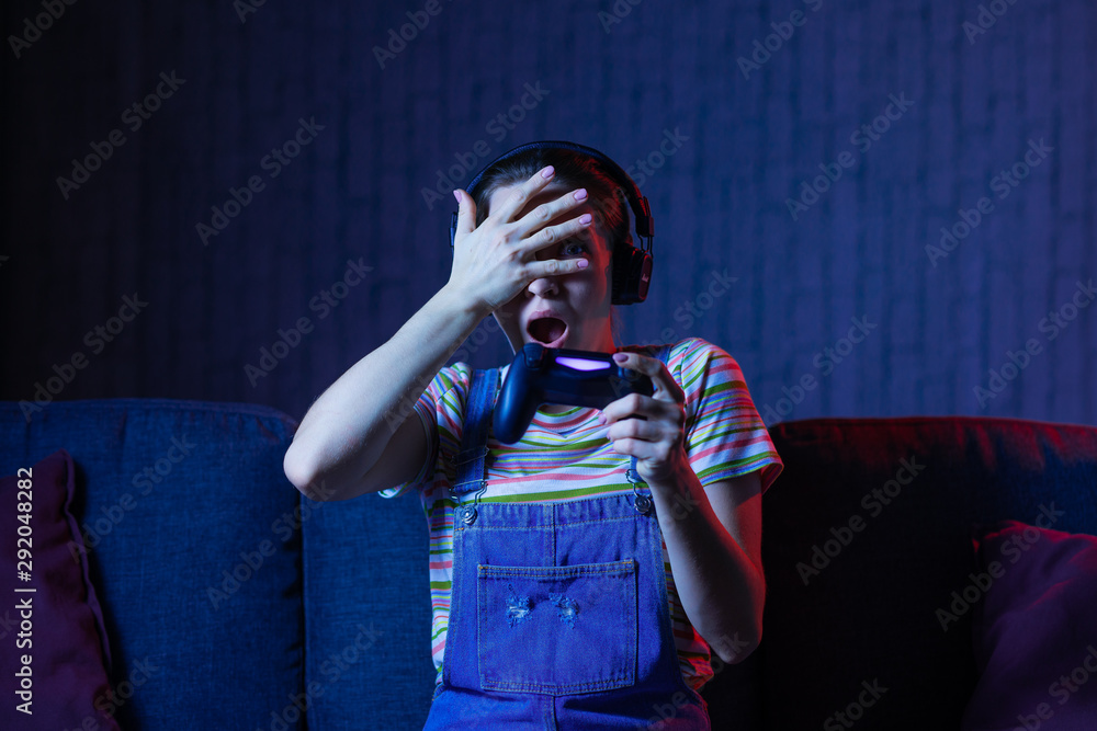 The gamer plays with the gamepad in the room in horror. The gamer plays with the gamepad in the room in horror.