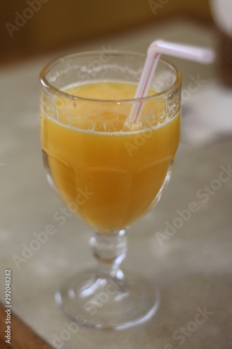 Glass of orange juice on wooden table