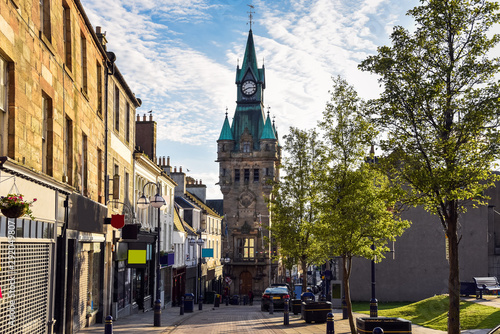 Pedestrian street lined with shops and traditional architecture in a town centre at sunset. Dunfermline, Scotland, UK.