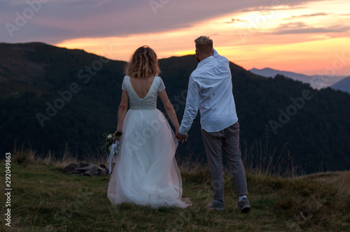 Beautiful wedding couple, bride and groom, in love on the background of mountains. Wedding in mountains . Beauty of carpathian mountains, Ukraine. Sunset time