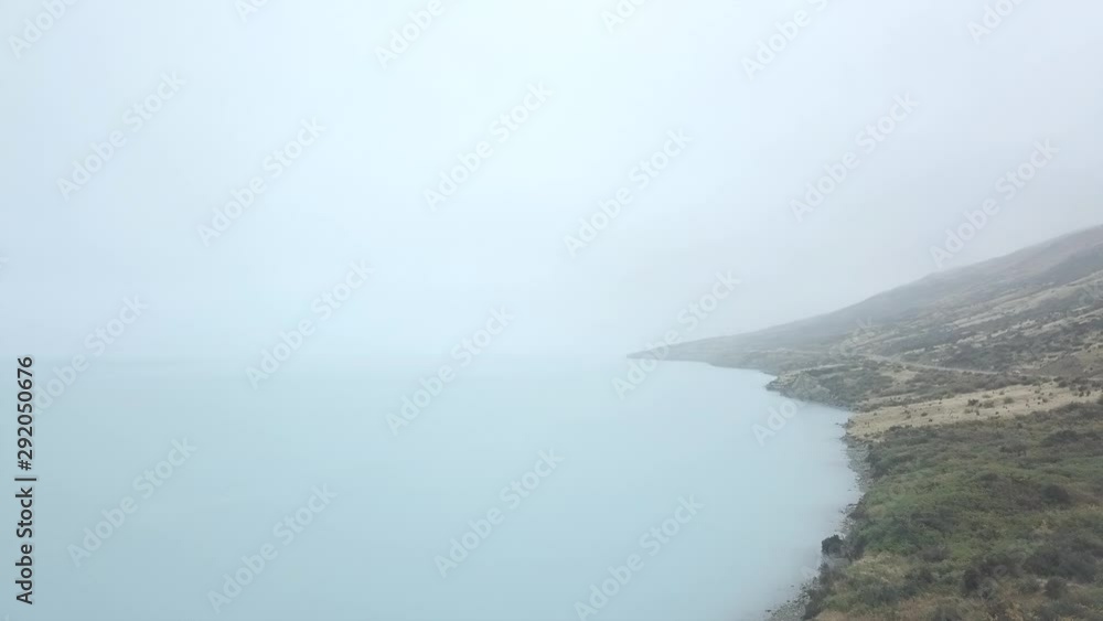 Scenic mountain silhouettes across lake with hazy horizon Scenic mountain silhouettes across lake with hazy horizon
