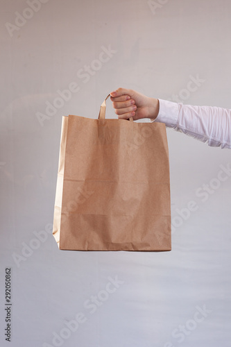 Young woman is carrying a brown delivery craft paper bag