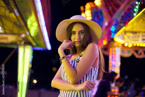 Pretty young woman against the background of magical bright carousel lights. © bodiaphoto