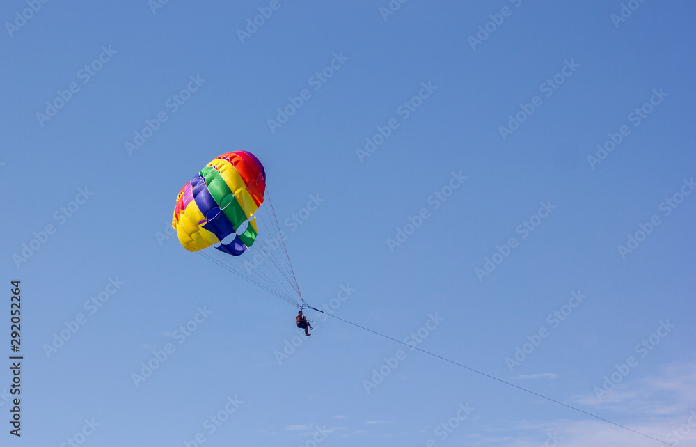 parachuting over the sea entertaining tourists at sea on vacation on the beach parachuting over the sea entertaining tourists at sea on vacation on the beach