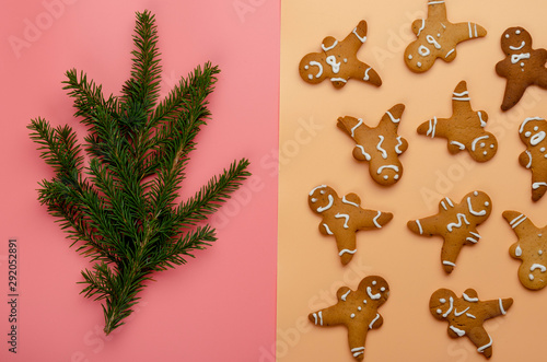 Homemade christmas cookies on pink and peach background. Pattern of gingerbread men and fir tree. New year concept.