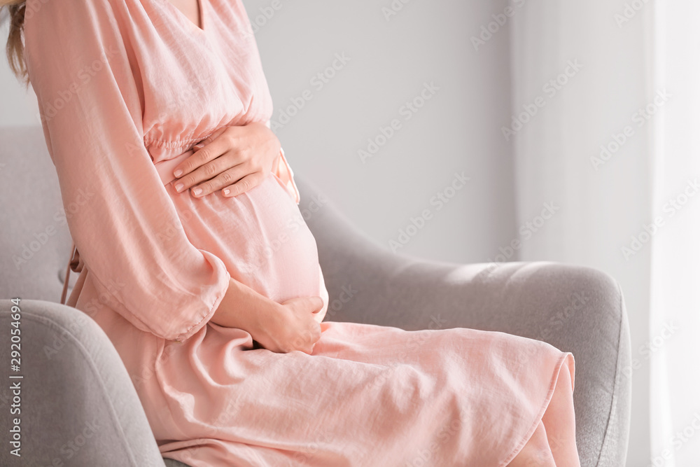 Beautiful pregnant woman sitting in armchair at home Beautiful pregnant woman sitting in armchair at home