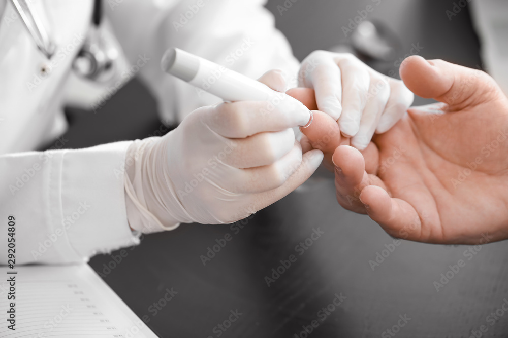 Doctor taking blood sample of diabetic man in clinic, closeup Doctor taking blood sample of diabetic man in clinic, closeup