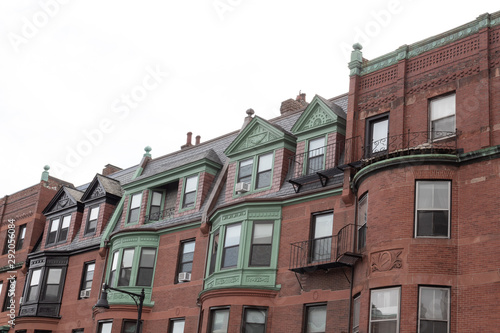 Front of old brownstone apartment buildings showing a variety of architectural styles and finishes, horizontal aspect