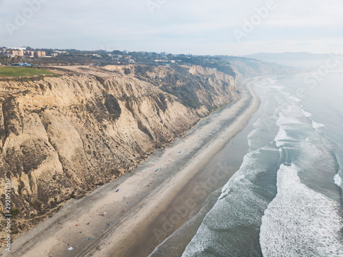 Ocean waves along coastal sand dunes aerial landscape