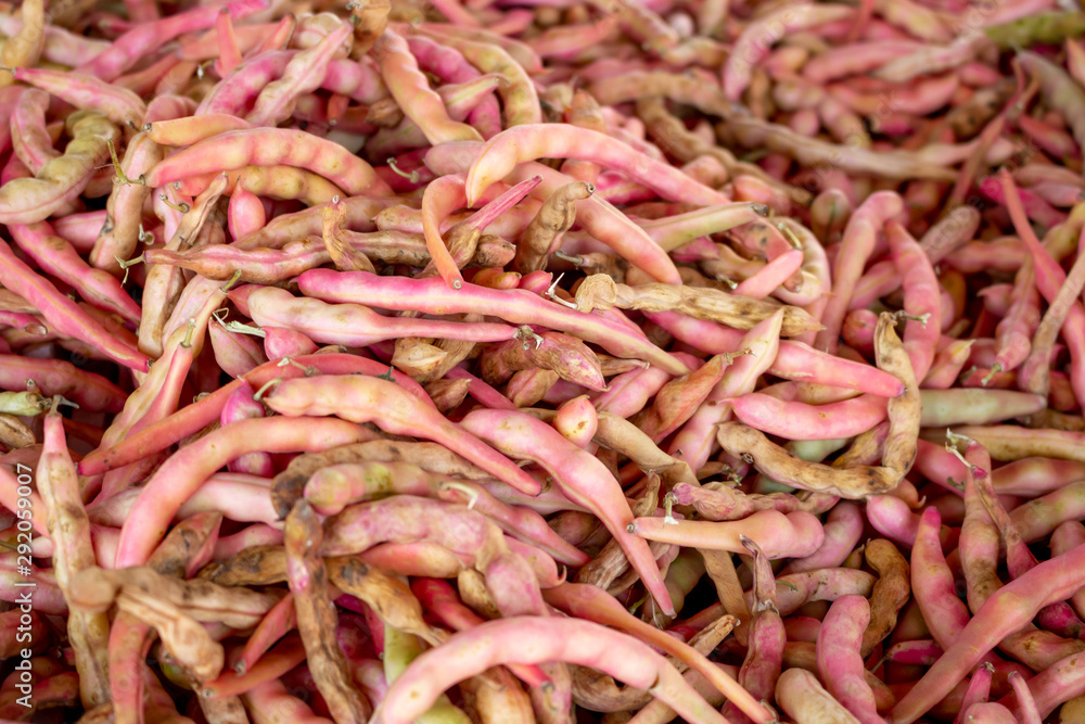 A background of red pea pods on display at a local grocery store.