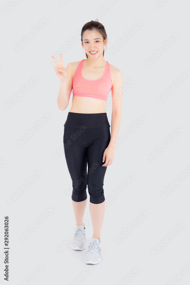 Beautiful portrait young asian woman in sport clothes with satisfied and confident gesture finger v sign isolated on white background, asia girl have shape and wellness, exercise for fit with health. Beautiful portrait young asian woman in sport clothes with satisfied and confident gesture finger v sign isolated on white background, asia girl have shape and wellness, exercise for fit with health.
