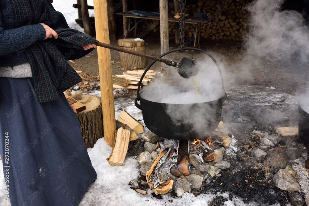 Ταπετσαρία Woman in pioneer garb ladling evaporating sap in cast iron pot to produce maple