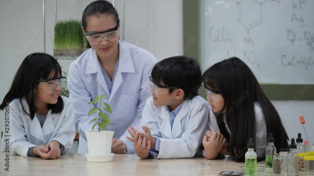 Asian teacher teaching agricultural to children in the classroom at school. Little boy and girl learning plant chlorophyll in modern laboratory together. Concept of education, science and technology. Asian teacher teaching agricultural to children in the classroom at school. Little boy and girl learning plant chlorophyll in modern laboratory together. Concept of education, science and technology.