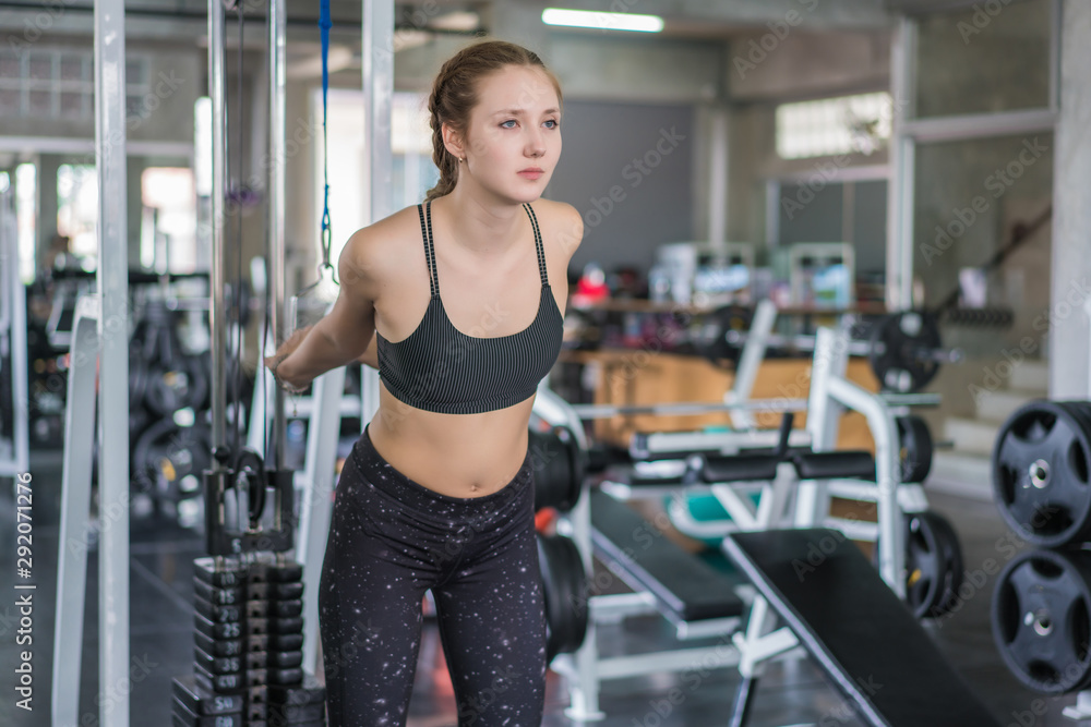Fototapeta premium Athlete sporty woman doing exercise with fitness trx straps to strengthen his abdominal muscle in gym