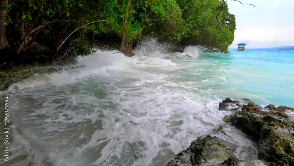 huge waves splashes into rocky shoreline