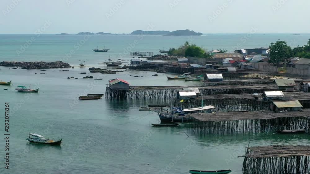 Aerial Drone Video flying above Fishing Village of Tanjung Binga in Belitung Island Indonesia. Fishing Boat on Clear water, village houses Aerial Drone Video flying above Fishing Village of Tanjung Binga in Belitung Island Indonesia. Fishing Boat on Clear water, village houses