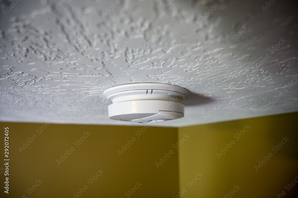 residential smoke detector mounted on white ceiling - obrazy, fototapety, plakaty 