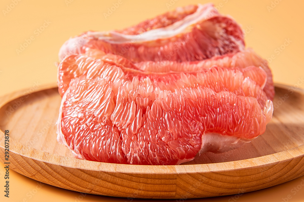 A plate of fresh red grapefruit meat on a yellow background A plate of fresh red grapefruit meat on a yellow background