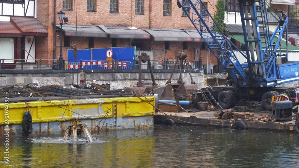 River Dredging Machinery Lifts Sand and Mud with Giant Shovel from River Bottom River Dredging Machinery Lifts Sand and Mud with Giant Shovel from River Bottom